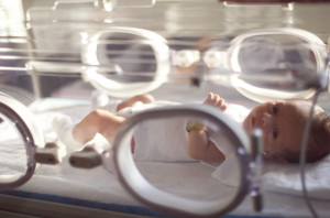 a caucasian newborn baby lays recovering in a hospital